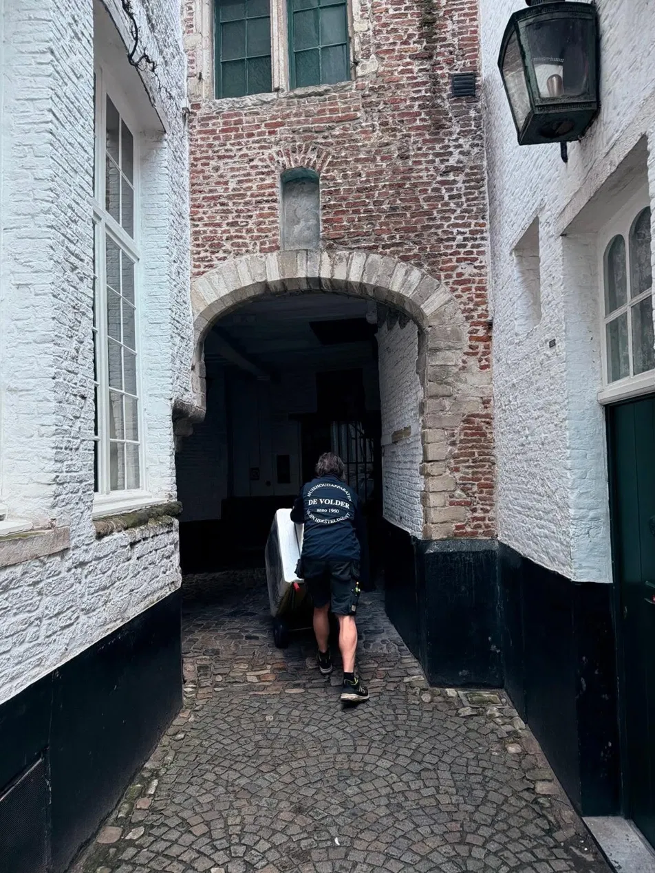 Technieker van De Volder levert een toestel door een Antwerpse steeg